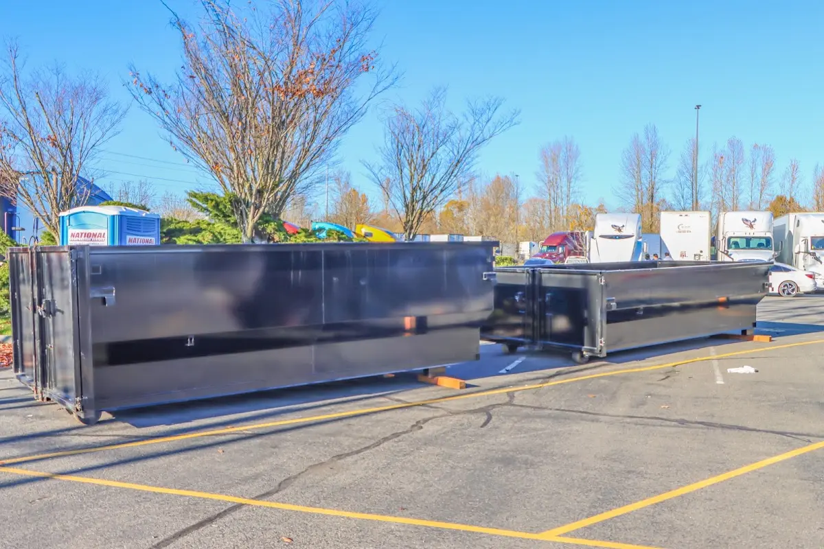 Professional dumpster rental service with roll-off container on residential driveway in St. Ann